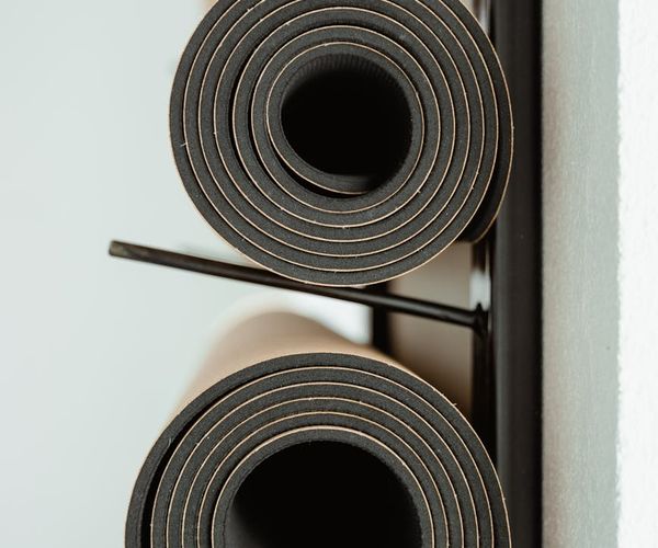 Welcoming and bright yoga studio interior with rolled mats.